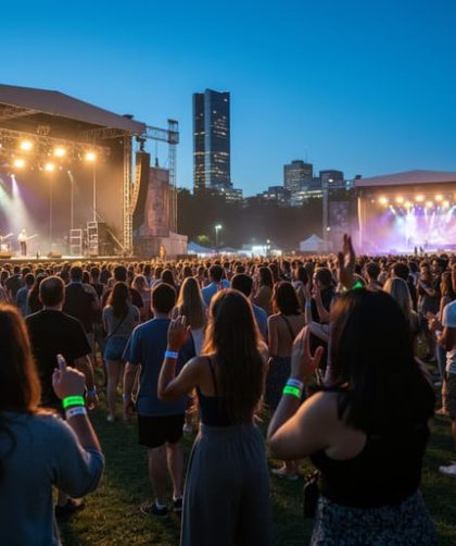 “Evening view of multiple illuminated music stages at LeBreton Flats during Ottawa Bluesfest with a diverse crowd in the foreground.”